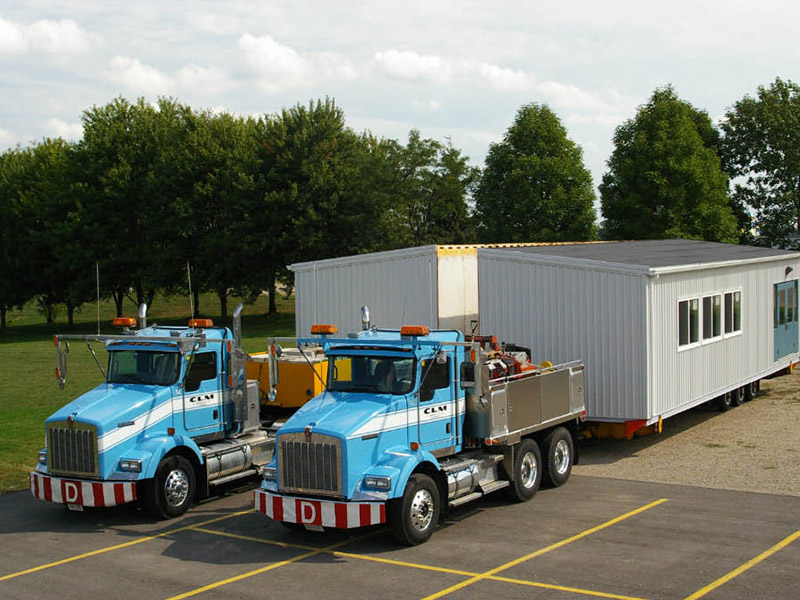 Trucks are loaded with both halves of a classroom